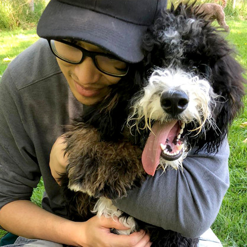 Dog trainer Sean hugging a furry dog.